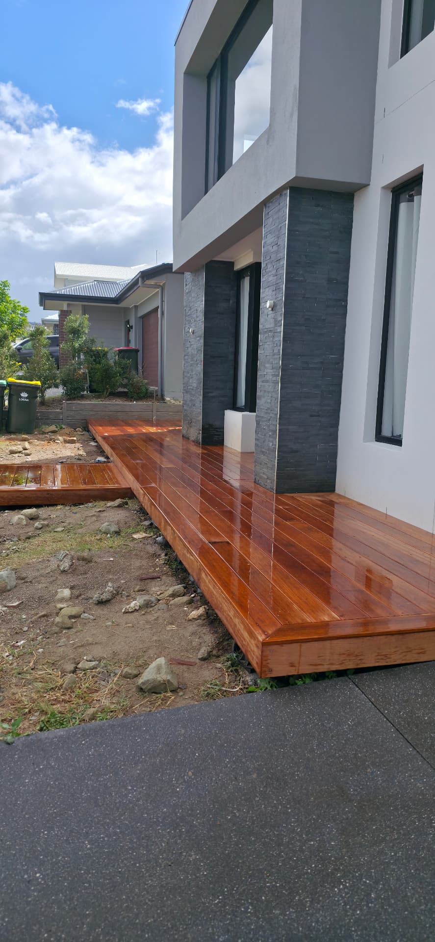 Freshly oiled side deck along modern home