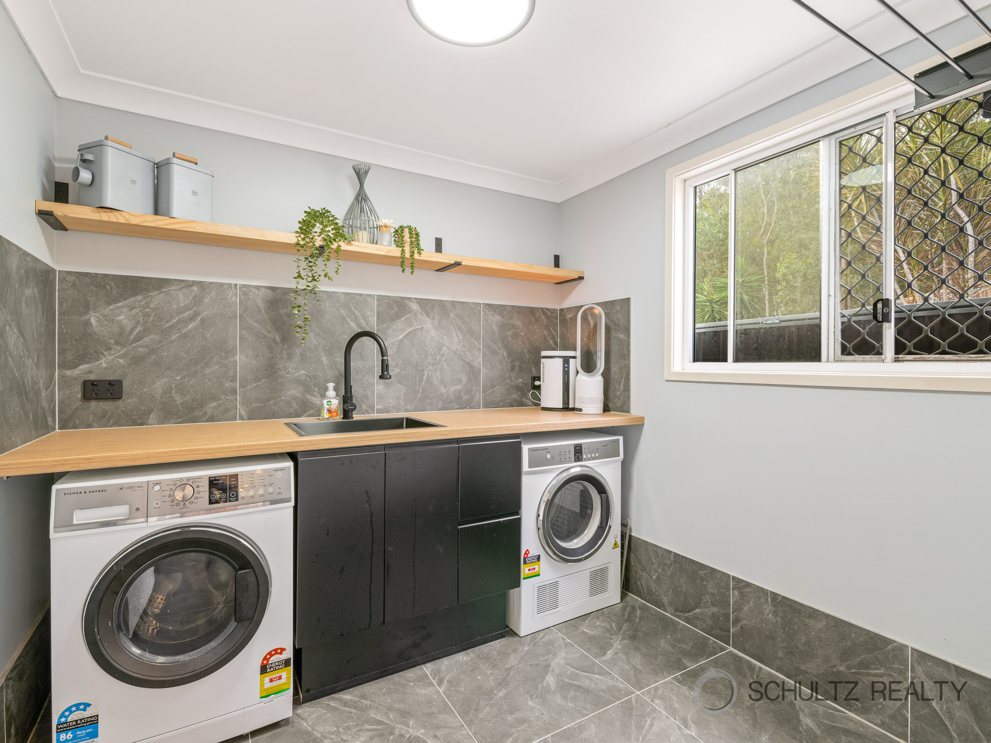 Compact organized laundry room with custom shelving